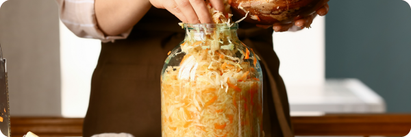 Someone making homemade sauerkraut a fermented food good for your gut health.