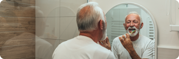 A person brushing their teeth, taking care of their oral health which is another health indicator.
