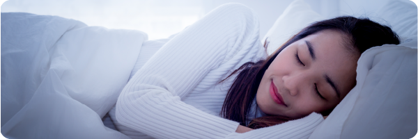 A person asleep in bed, representing the energy and sleep health indicators.