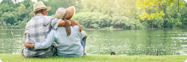 A couple sat by the edge of a river.