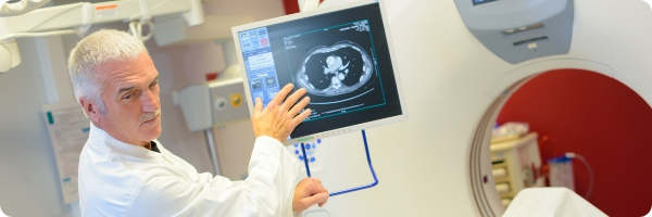 Doctor with a patient gestures to prostate scan on a computer screen.