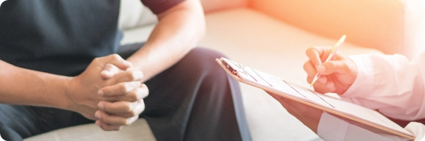 Man sits with a doctor in a white coat to  discuss prostate health.
