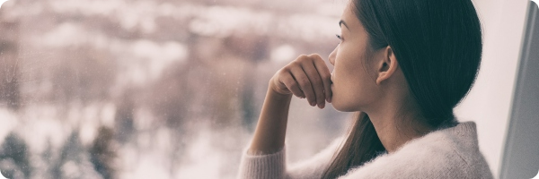 Woman staring out of a window.