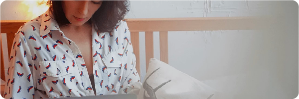 Ditch the tech before bed sleep tip. image shows a young woman looking at screen while in bed. 