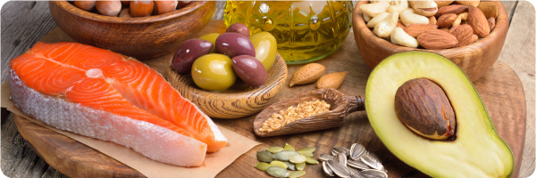 Eat healthy fats for better sleep. Image shows salmon, avocado and other food sources of healthy fats.  