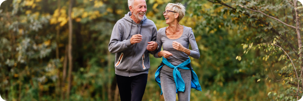A couple jogging outside together in nature.
