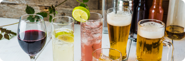 A table with a selection of different alcoholic beverages in different glasses: wine, beer and mixers.