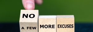 A finger turning over a dice which says 'A few' to reveal the word 'No' on the other side. Two other dice next to it says 'more excuses'.