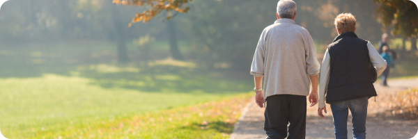 A couple walking in the park, green spaces to support lung health.